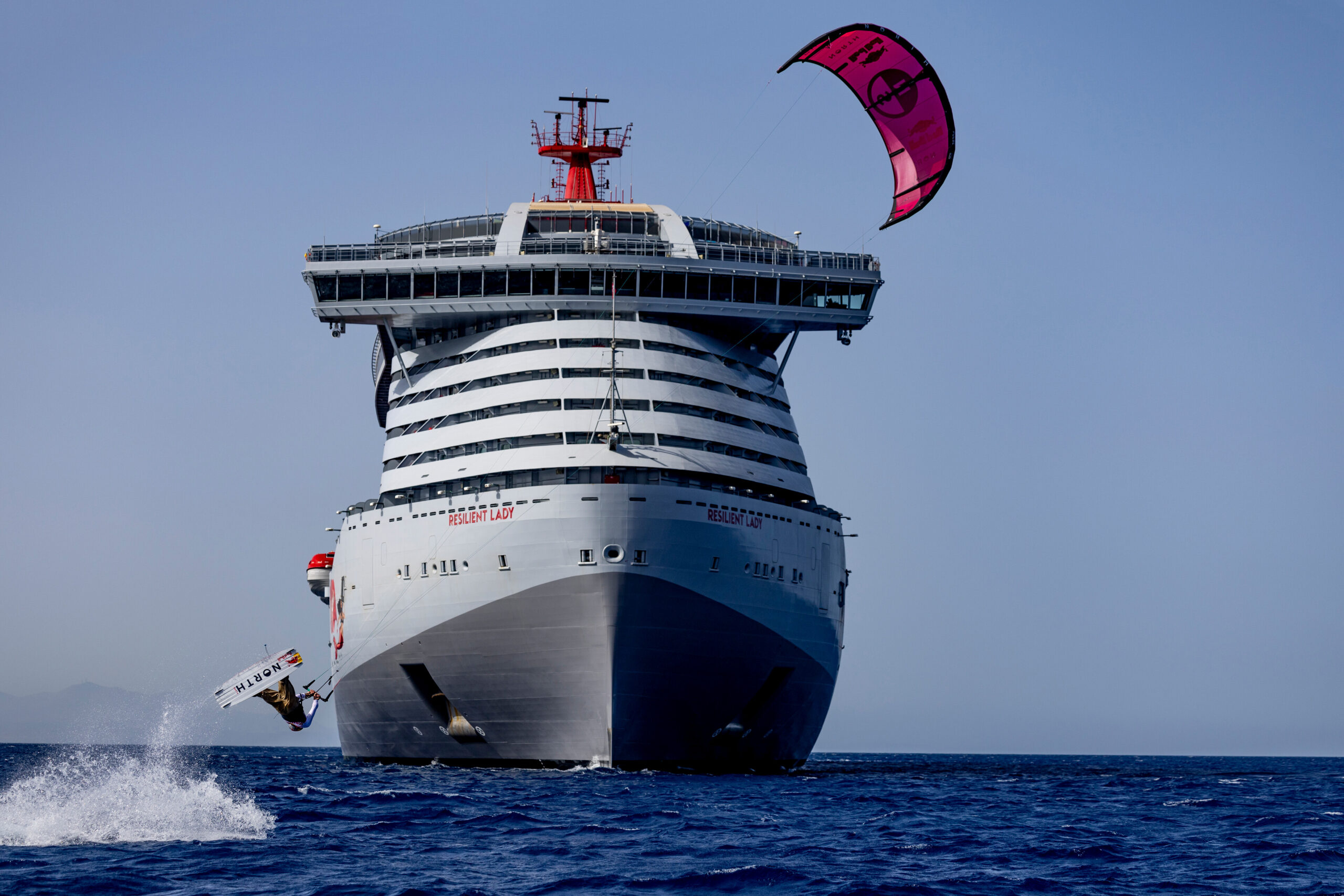 Tom Bridge completes his kitesurf from Deck 16 of Virgin Voyages' Resilient Lady, approximately 129 feet above the harbor of Delos, Greece. CREDIT: Alex Grymanis / Red Bull