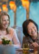 Women laugh over wine aboard a Uniworld river ship. CREDIT: Uniworld