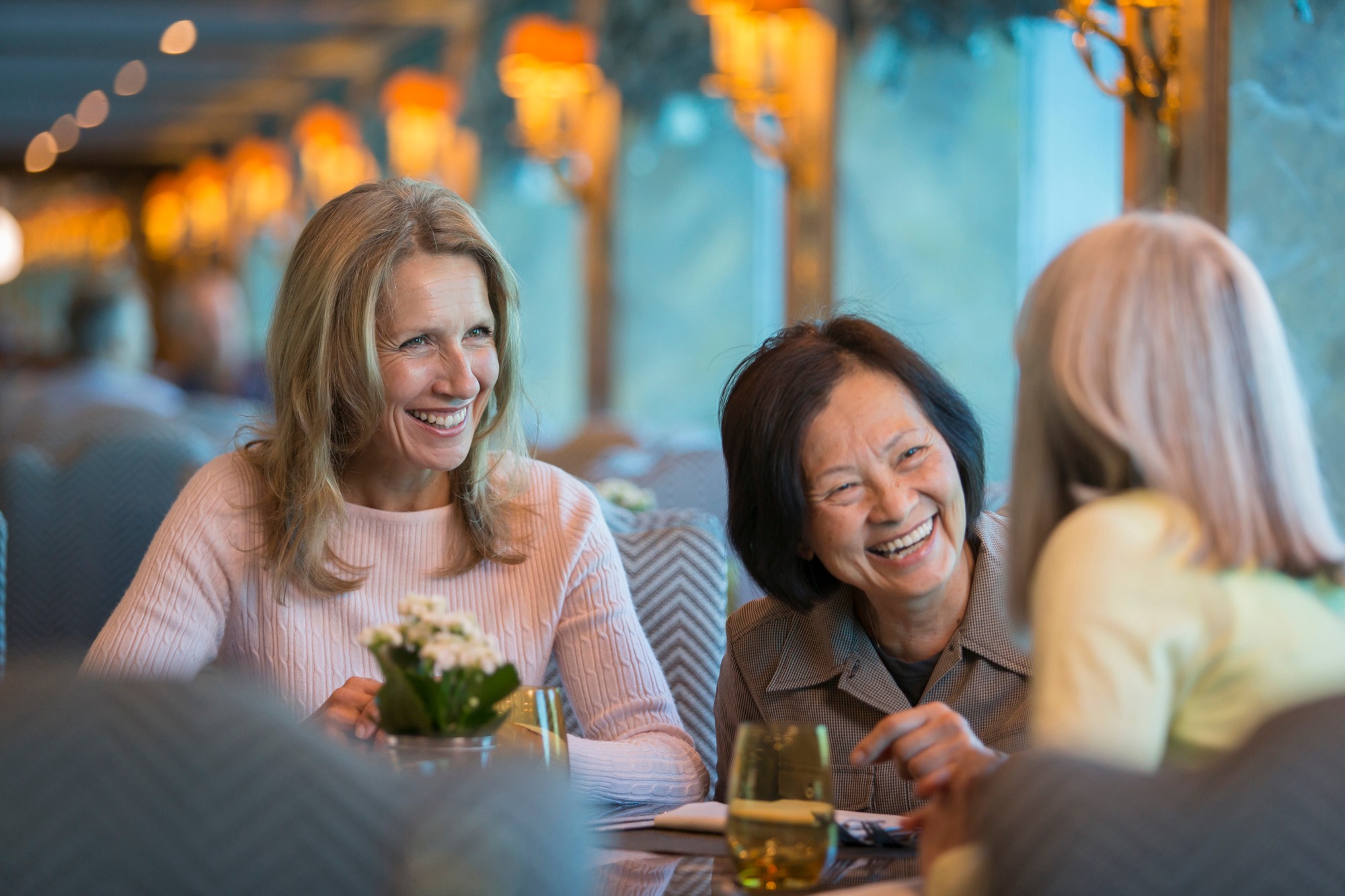 Women laugh over wine aboard a Uniworld river ship. CREDIT: Uniworld